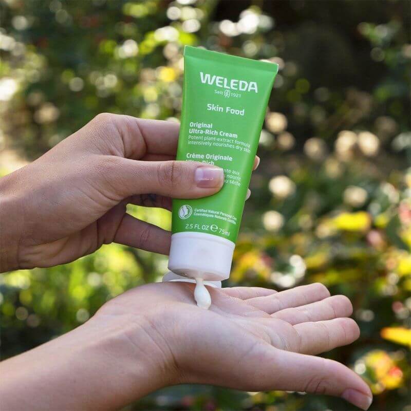 woman holding organic skin care product in green package
